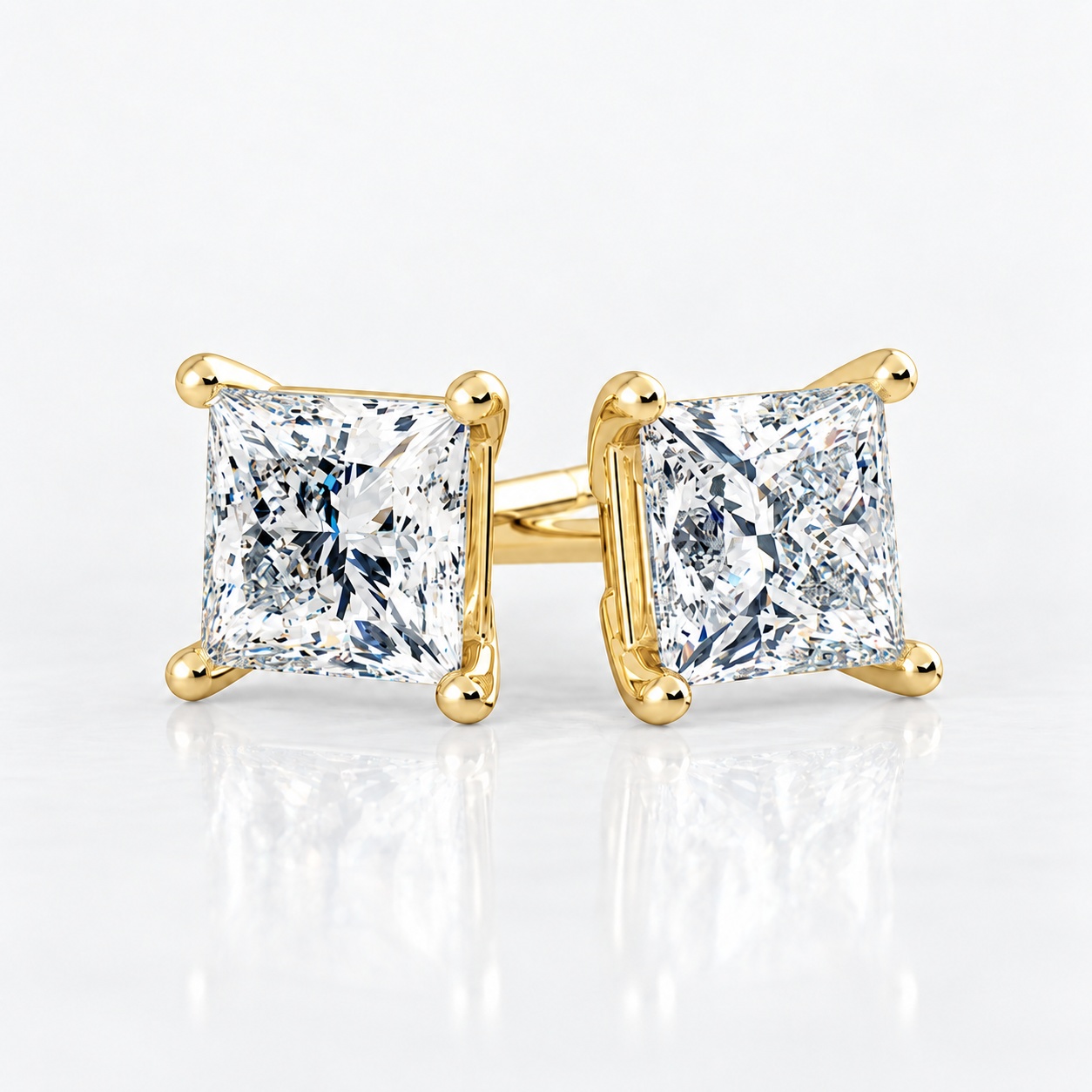 Four-claw princess diamond stud earrings in yellow gold