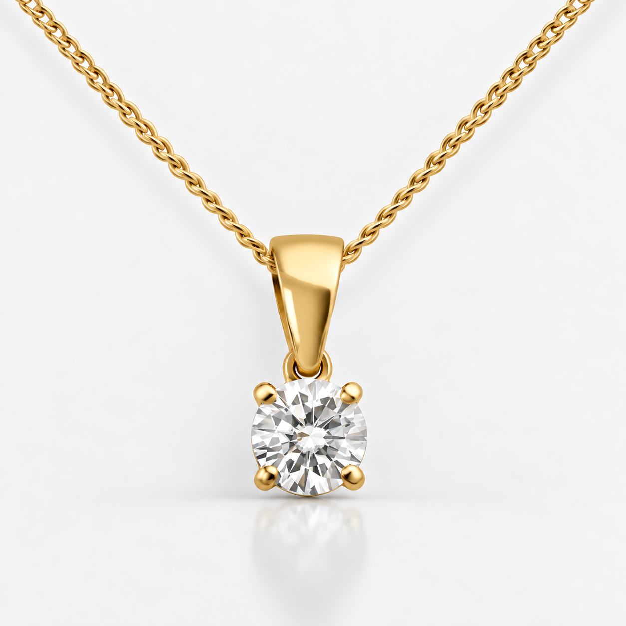 Front view of a four-claw round diamond solitaire pendant in yellow gold with a fine curb chain