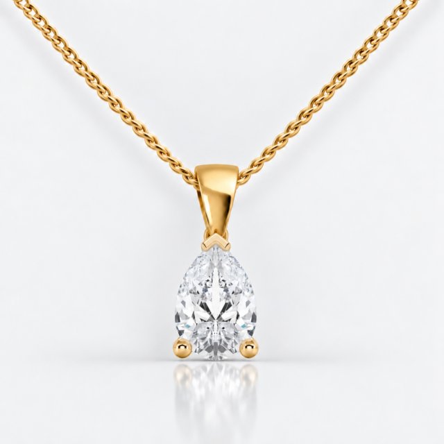 Front view of a three-claw pear diamond solitaire pendant in yellow gold with a fine curb chain