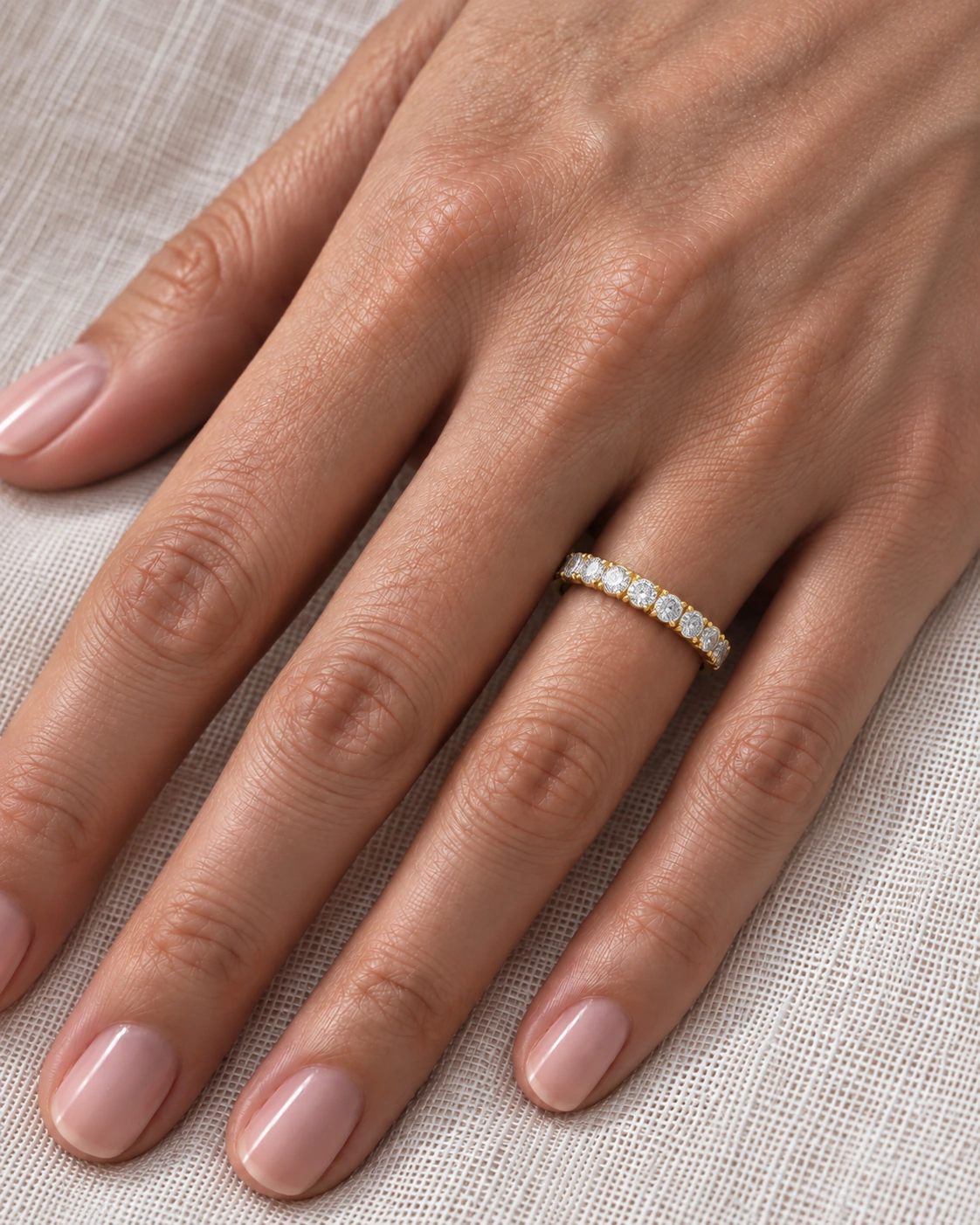 2.25mm scallop set diamond eternity ring in yellow gold worn on the ring finger