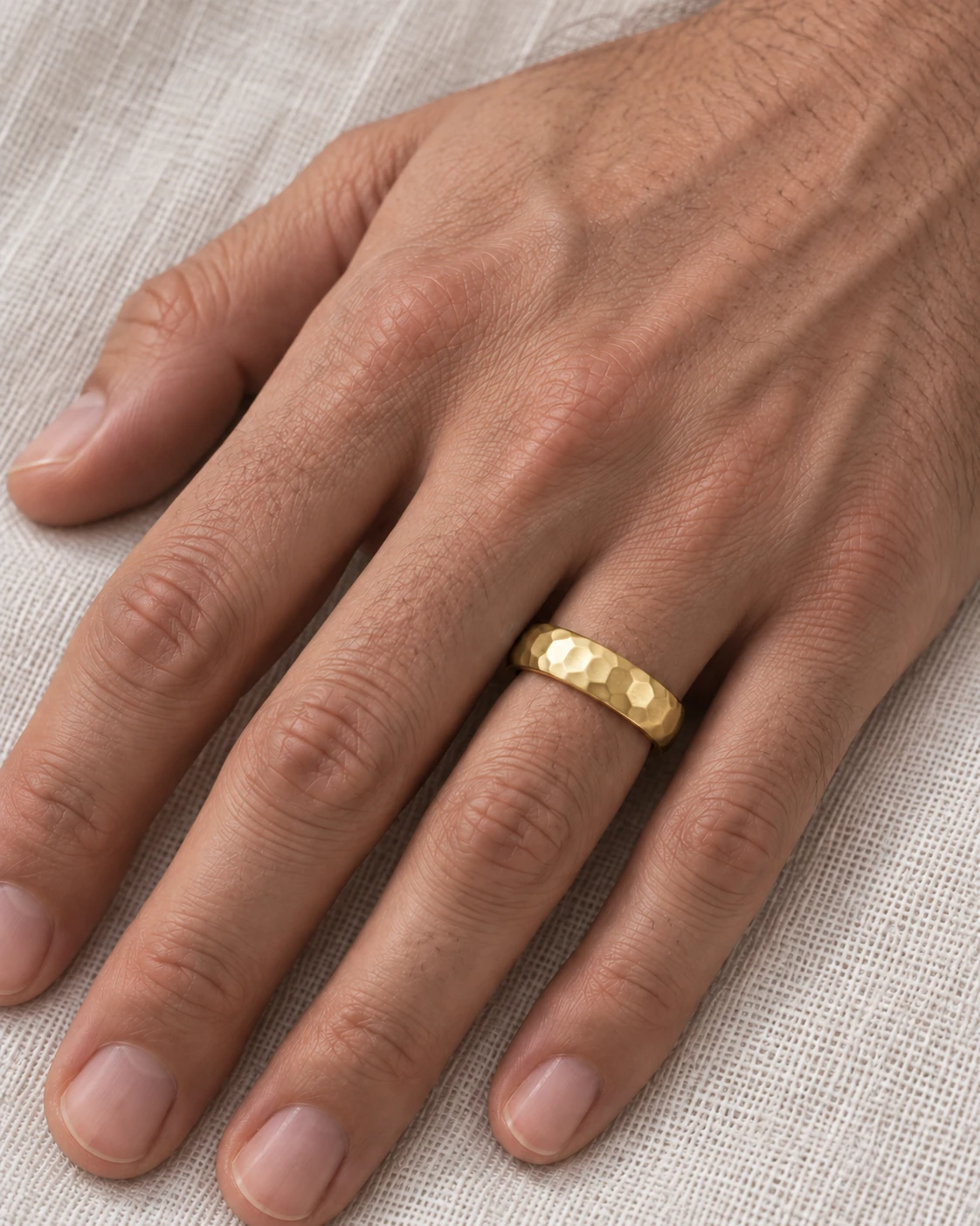 5.5mm Hammered Wedding Band in yellow gold worn on the ring finger