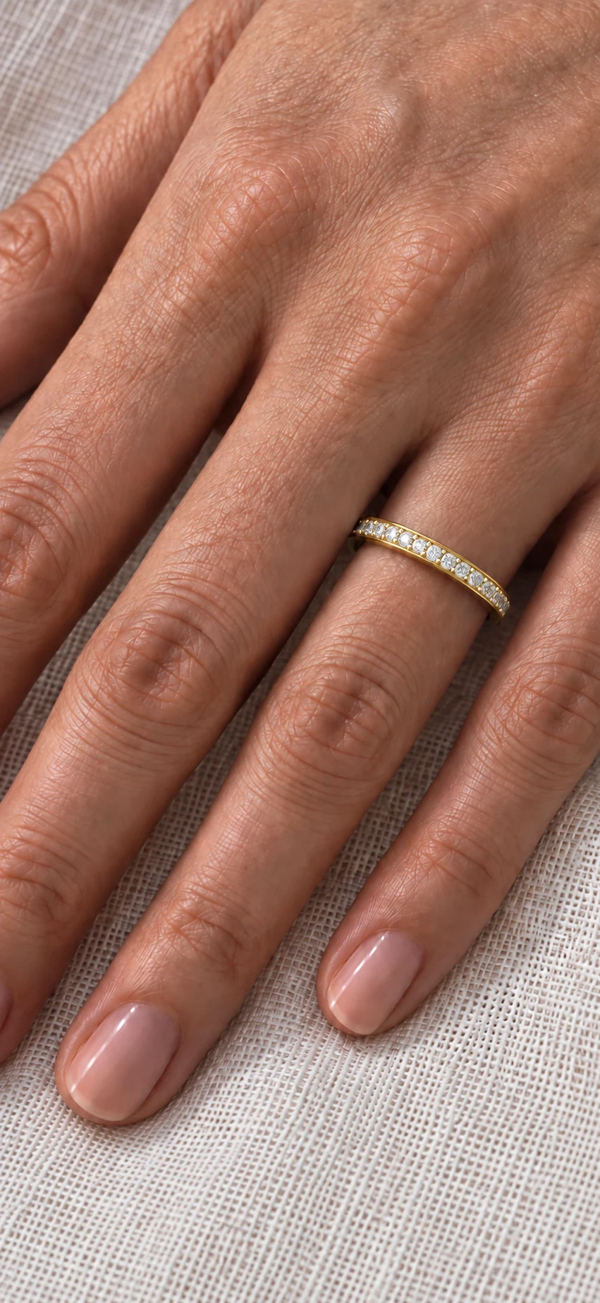 2mm pavé set diamond eternity ring in yellow gold worn on the ring finger