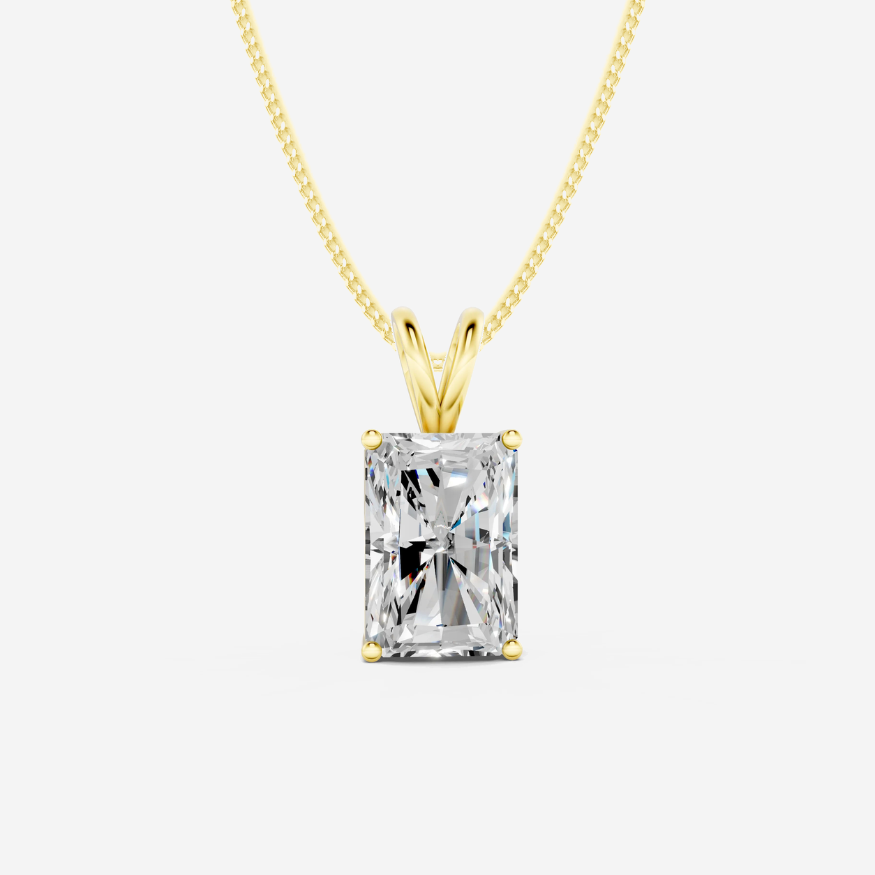 Four-claw radiant diamond solitaire pendant with a matching yellow-gold diamond-cut curb chain.